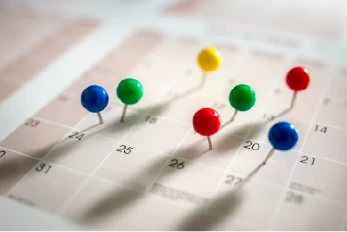 Photo of a calendar with pins on dates